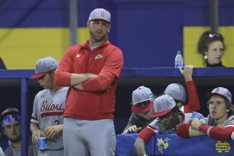 Head coach looks on from the dugout.