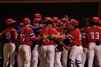 Baseball team celebrating near the dugout.